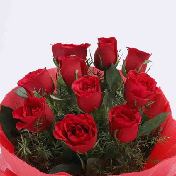 10 red roses with small green leaves wrapped in red paper